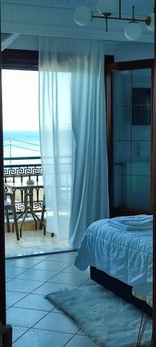 a bedroom with a bed and a view of the beach at l' atoll d' Helene in Gythio