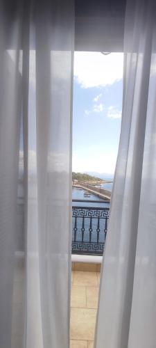 a window with a view of the ocean from a balcony at l' atoll d' Helene in Gythio