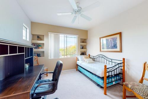 ein Schlafzimmer mit Bett, Schreibtisch und Fenster in der Unterkunft Vistoso Golf Casitas II #209 in Oro Valley