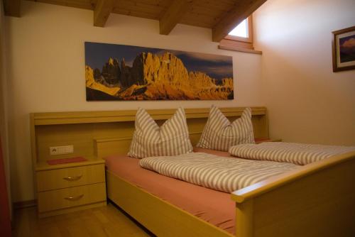 ein Schlafzimmer mit 2 Betten und einem Wandgemälde in der Unterkunft Messner Hof in Tiers