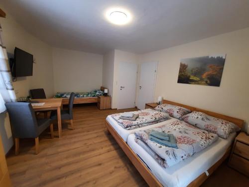 a bedroom with a bed and a desk and a table at Kirchenwirt in Kaumberg