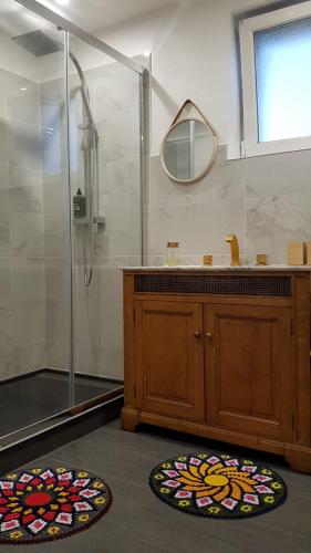 une salle de bain avec une douche et deux tapis circulaires dans l'établissement VILLA RIVIERE, à Bagnols-sur-Cèze