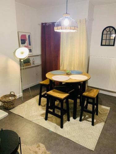 une salle à manger avec une table, des chaises et une lampe dans l'établissement Appartement centre ville, à Dunkerque