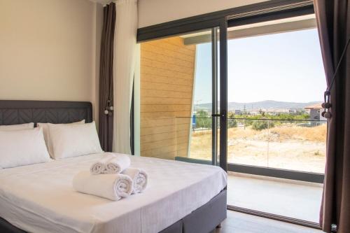a bedroom with a bed with towels on it at Lovely Villa with Private Pool in Alacati Cesme in Alacati