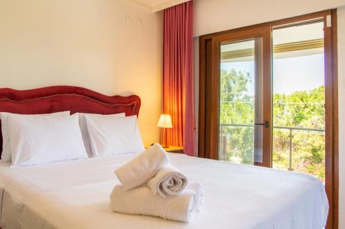 a hotel room with a bed with a towel on it at Enchanting Villa with Backyard in Cesme near Beach in Alacati