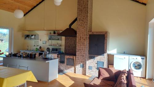 a kitchen with a brick fireplace in a kitchen with a stove at Vakari Puhketalu in Vakari