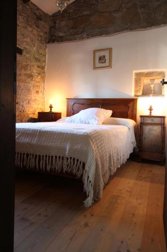 a bedroom with a large bed in a brick wall at Casale Don Giovanni in Prepotto