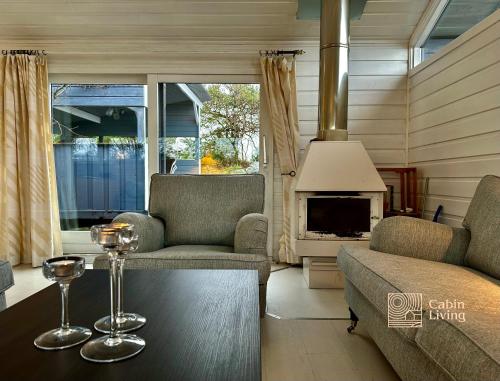 a living room with a couch and a table and a fireplace at Fantastic Sea Cottage on Justøya Island, Lillesand in Lillesand