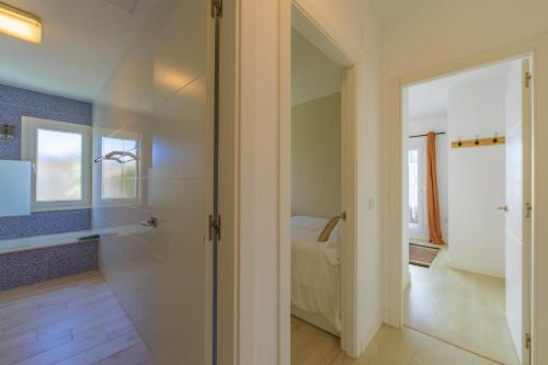un pasillo con una puerta de cristal que conduce a un dormitorio en La Reserva Bajo E, en Tarifa