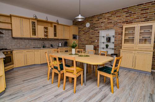 a kitchen with a table and chairs and a brick wall at Kossuth Vendégház in Tolna