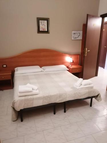 a bedroom with a large bed with a wooden headboard at Il Leone D'Oro in Telgate