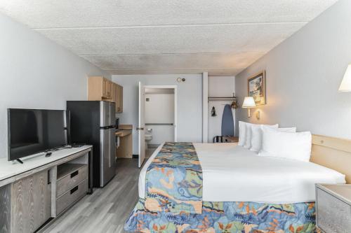 um quarto de hotel com uma cama e uma televisão de ecrã plano em Vivo Flex Living Kissimmee em Kissimmee