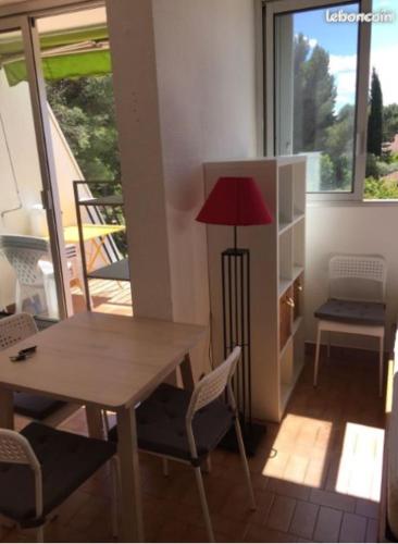 une salle à manger avec une table, des chaises et une lampe dans l'établissement MER & LAC SOLEIL, à La Grande Motte