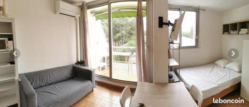 - un salon avec un canapé, un lit et une fenêtre dans l'établissement MER & LAC SOLEIL, à La Grande Motte