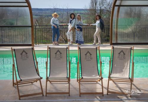 a group of people standing by a swimming pool with chairs at Holiday home Le clos du phare in Saint-Samson-de-la-Roque