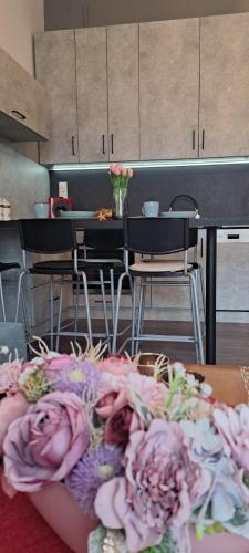 a kitchen with a table with pink flowers on it at Napraforgó apartman in Szeged