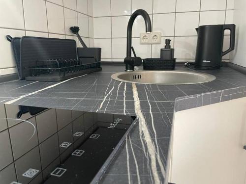 a kitchen counter top with a sink and a sink at Modernes Apartment in Chemnitz in Chemnitz