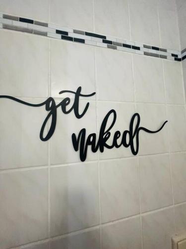 a white tiled wall with the words get married on it at Modernes Apartment in Chemnitz in Chemnitz