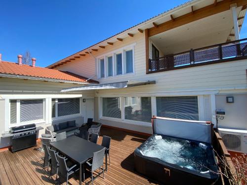 a patio with a table and a hot tub on a house at Stunning 5BR 16 Bed Home with Finnish Sauna & Jacuzzi 340 m2 in Tampere