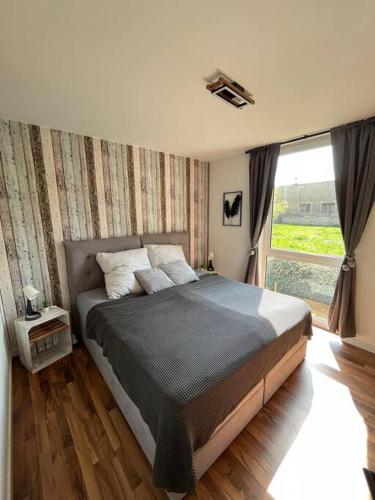 a bedroom with a bed and a large window at Modernes Apartment in Chemnitz in Chemnitz