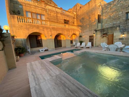 a swimming pool in the courtyard of a building at Villa Serenita in Xagħra