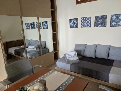 Habitación pequeña con cama y espejo. en Zennova #3 Mount Athos & Sea View, en Pyrgadikia
