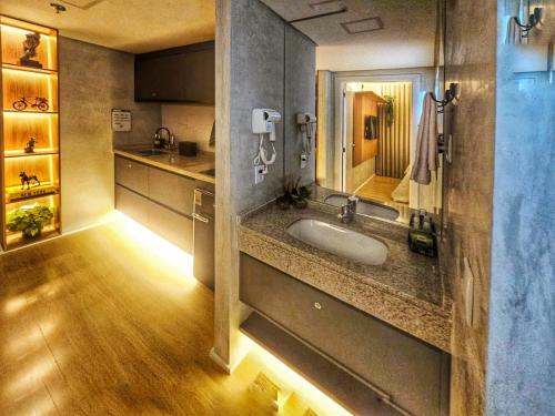 a large bathroom with a sink and a mirror at Conforto no melhor do Marista & Goiânia in Goiânia