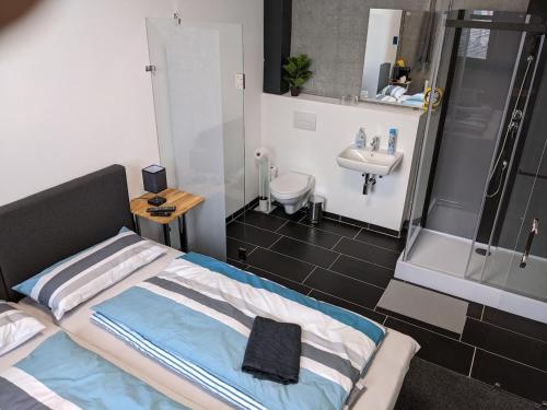 a small bathroom with a bed and a sink at Business-Motel, Night-Checkin, Breakfast 2go, XL-Parking, free WiFi in Heimsheim