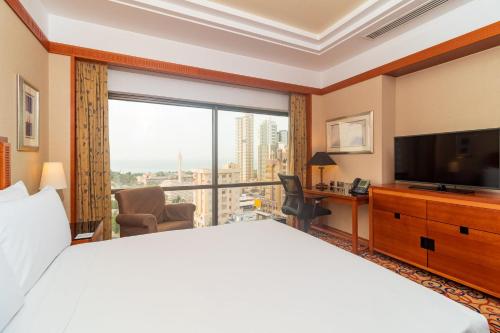 a hotel room with a large bed and a large window at Holiday Inn Kuwait by IHG in Kuwait