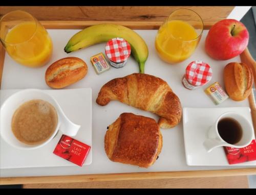 a tray of food with a breakfast of croissants and orange juice at Rodez centre ville, Parking gratuit in Rodez