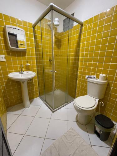 a bathroom with a shower and a toilet and a sink at Pousada Beijos y Abraços in Natal
