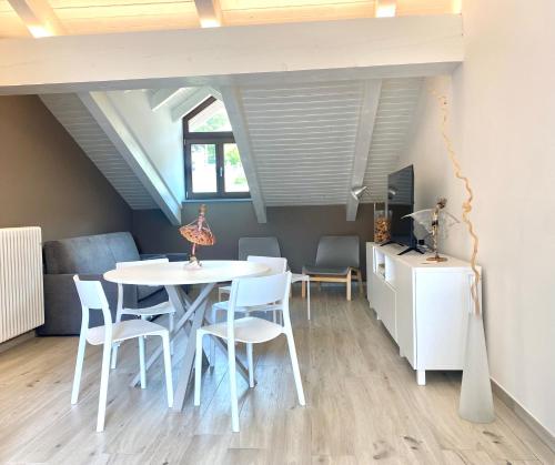 comedor con mesa blanca y sillas en Casa di Nuvola -Residenza Lavinia -, en Monforte dʼAlba