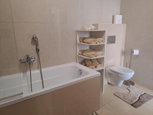 La salle de bains est pourvue d'une baignoire, de toilettes et de serviettes. dans l'établissement Apartmán Mila, Tatragolf C407, à Veľká Lomnica