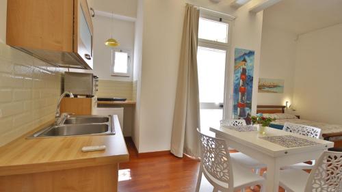 eine Küche mit einem Waschbecken und einem Tisch mit Stühlen in der Unterkunft Casa Levante a 75 mt dalla spiaggia in Monopoli