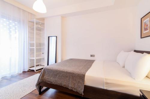 a white bedroom with a bed and a window at Stylish Flat with Central Location in Sisli in Istanbul
