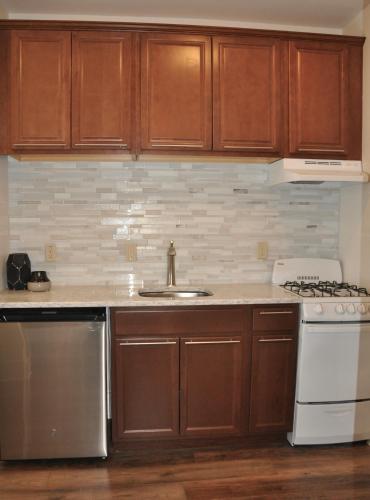 a kitchen with wooden cabinets and a sink and a stove at Luxury Studio w KIT DT RC 30 mins fm Mt. Rushmore in Rapid City