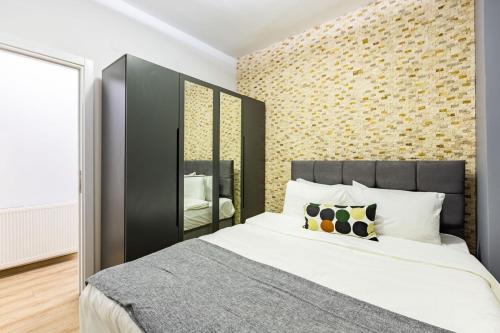 um quarto com uma cama grande e uma parede de tijolos em Distinguished Flat with Backyard in Sisli em Istambul