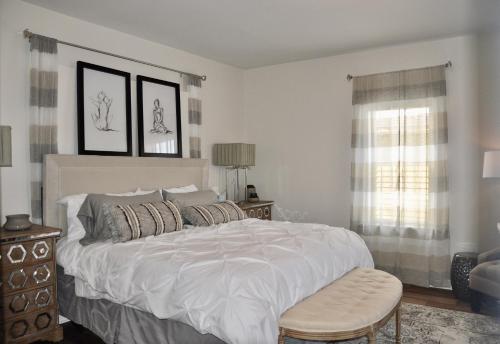 a bedroom with a large white bed and a chair at Luxury Studio w KIT DT RC 30 mins fm Mt. Rushmore in Rapid City