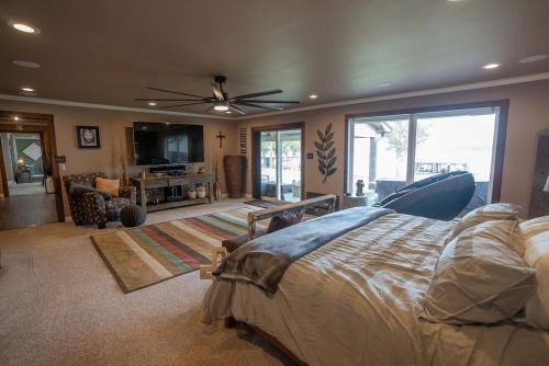 een slaapkamer met een groot bed en een woonkamer bij Luxury Waterfront Lakehouse Retreat - Piney Woods of East Texas - Lake Palestine in Chandler