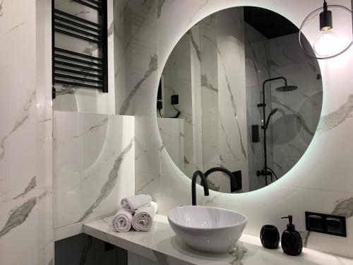 ALLURE PREMIUM APARTMENT في لوبلين: حمام مع حوض ومرآة
