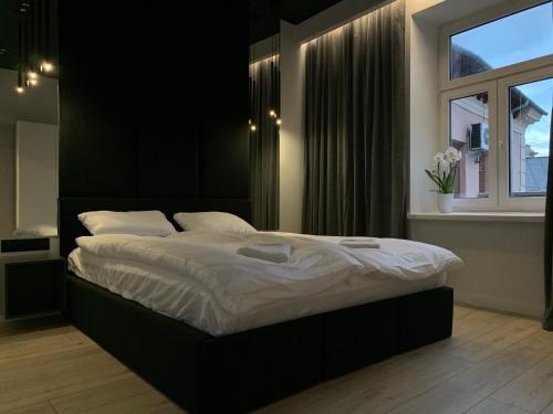 1 cama grande en un dormitorio con ventana en ALLURE PREMIUM APARTMENT en Lublin