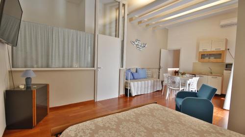 a bedroom with a bed and a kitchen and a table at Casa Levante a 75 mt dalla spiaggia in Monopoli