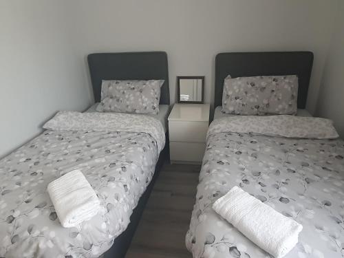 two beds sitting next to each other in a bedroom at Modern house in Dublin in Dublin