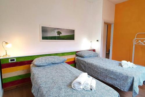 een ziekenhuiskamer met twee bedden en een schilderij aan de muur bij Eco Villetta di Beppina con giardino - Self Check-in in Pratovecchio