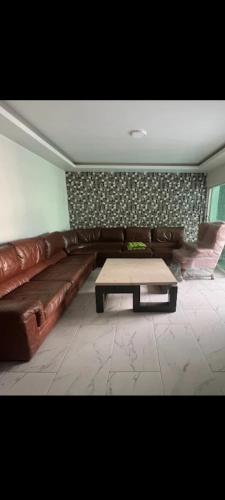 Sala de estar con sofá de cuero marrón y mesa de centro en Casa blanca, en Guadalajara