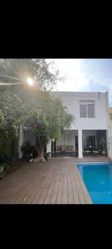 una casa con un árbol y una piscina en Casa blanca, en Guadalajara