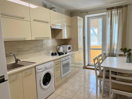 a kitchen with a sink and a washing machine in it at New Apartment "Family Estate" in Kamianets-Podilskyi