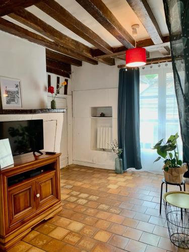 - un salon avec une télévision sur un meuble en bois dans l'établissement Les marches du château - Gîte centre de Nogent-le-Rotrou, à Nogent-le-Rotrou