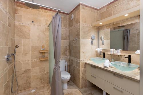 a bathroom with two sinks and a shower at En bord de plage Baie Nettlé, appart 4 couchages tout rénové in Saint Martin