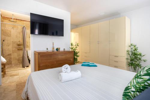 a bedroom with a bed with a tv on the wall at En bord de plage Baie Nettlé, appart 4 couchages tout rénové in Baie Nettle